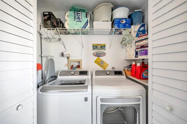 clothes washing area with a textured ceiling and washing machine and clothes dryer