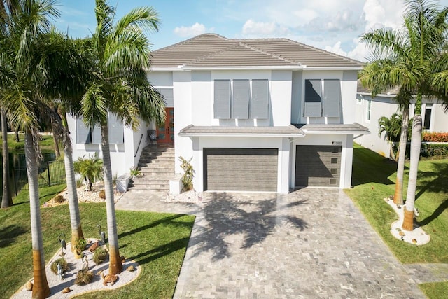 view of front of house featuring a garage and a front lawn