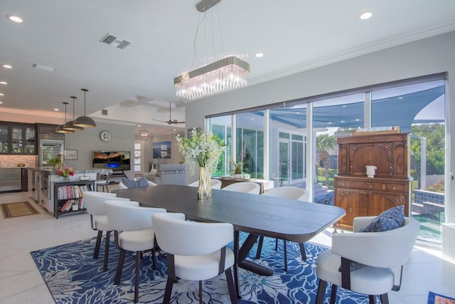 dining room featuring ceiling fan with notable chandelier and crown molding