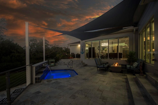 pool at dusk with pool water feature, an outdoor fire pit, and a patio area