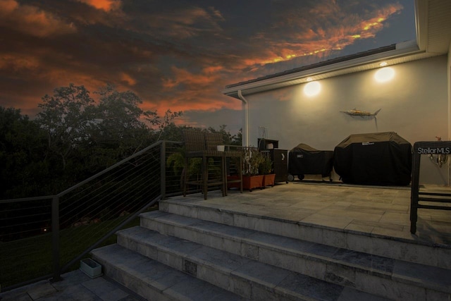 patio terrace at dusk featuring grilling area