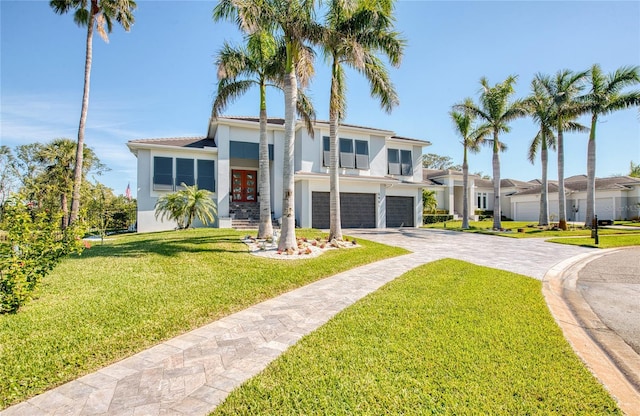 contemporary house featuring french doors, decorative driveway, an attached garage, and stucco siding