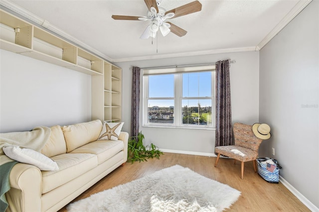 living area with crown molding, ceiling fan, and wood-type flooring