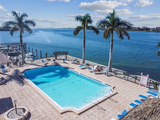 view of pool featuring a patio and a water view