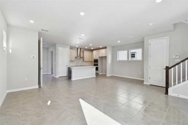 unfurnished living room featuring sink and light tile patterned floors