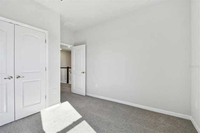 unfurnished bedroom with carpet flooring and a closet