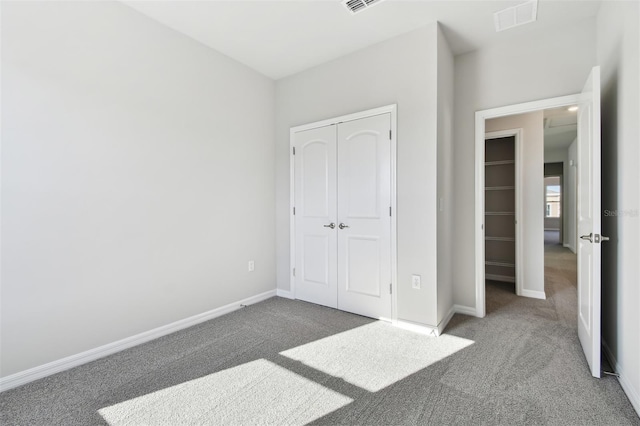 unfurnished bedroom featuring dark carpet and a closet