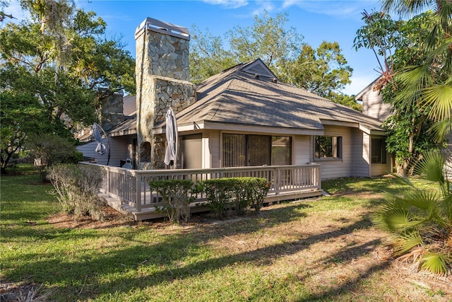 rear view of property with a yard and a deck