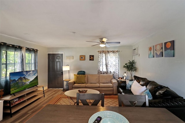 living room featuring hardwood / wood-style flooring, ceiling fan, a healthy amount of sunlight, and an AC wall unit