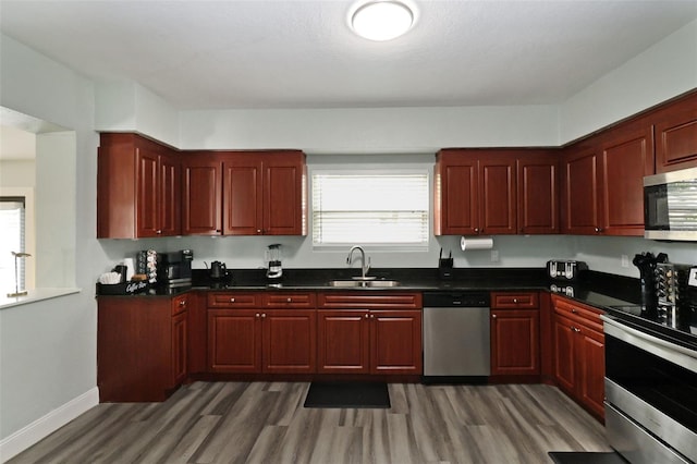 kitchen featuring appliances with stainless steel finishes, dark hardwood / wood-style flooring, and sink