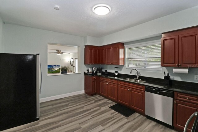 kitchen with ceiling fan, sink, stainless steel appliances, light hardwood / wood-style floors, and a textured ceiling