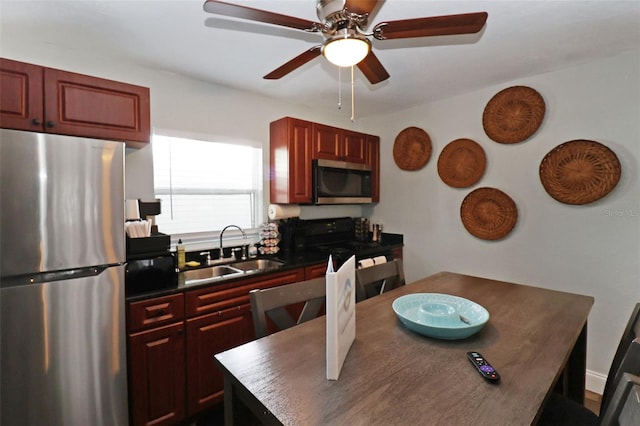 kitchen with ceiling fan, sink, a kitchen island, and stainless steel appliances