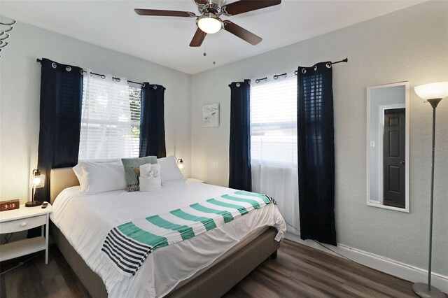 bedroom featuring multiple windows, ceiling fan, and dark hardwood / wood-style floors