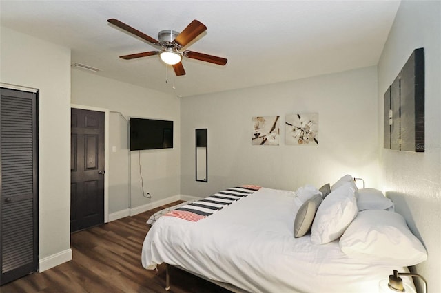 bedroom with ceiling fan, dark wood-type flooring, and a closet