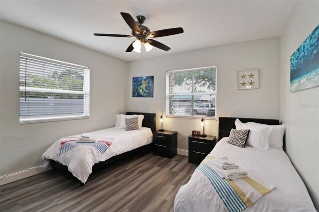 bedroom with dark hardwood / wood-style flooring, multiple windows, and ceiling fan