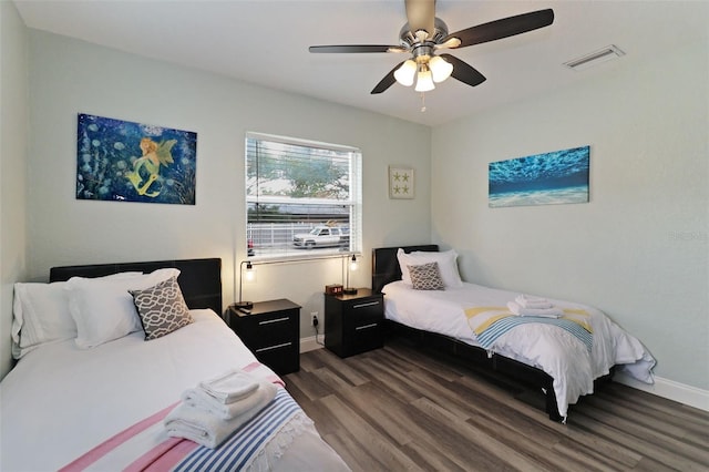 bedroom with dark hardwood / wood-style floors and ceiling fan