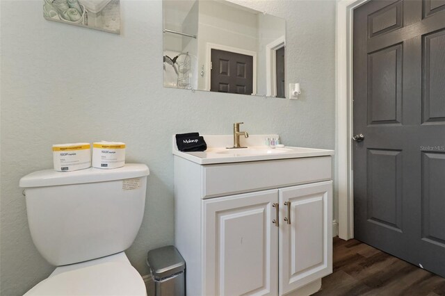 bathroom with vanity, toilet, and wood-type flooring