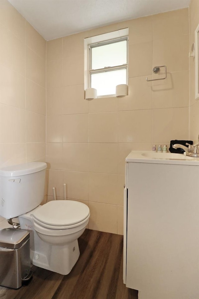 bathroom featuring toilet, vanity, tile walls, and hardwood / wood-style flooring