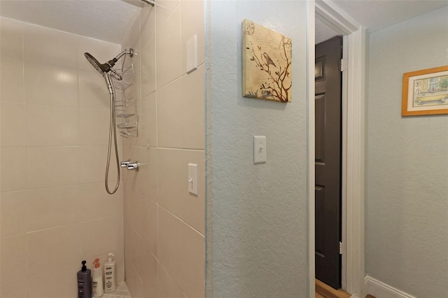 bathroom featuring a tile shower and a textured ceiling