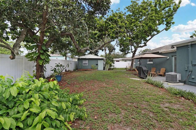 view of yard with central AC, a patio, and an outdoor structure