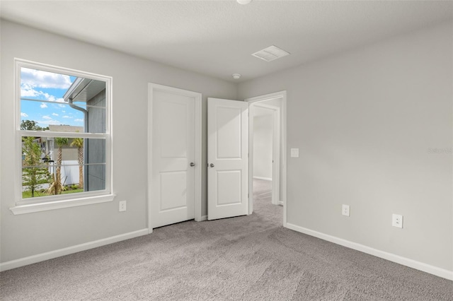 unfurnished bedroom with light colored carpet