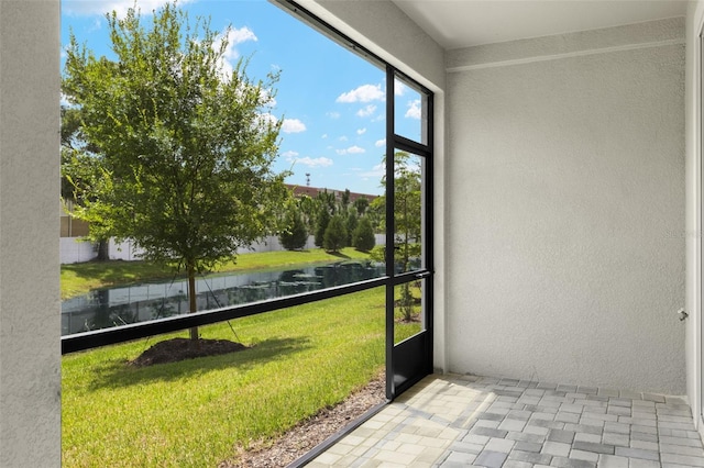 unfurnished sunroom featuring a water view