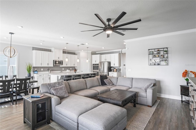 living room featuring wood-type flooring, ceiling fan with notable chandelier, and crown molding