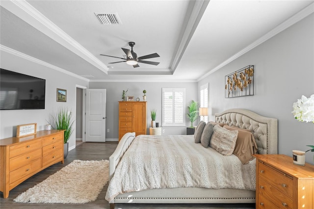 bedroom featuring a raised ceiling, ceiling fan, dark hardwood / wood-style flooring, and ornamental molding