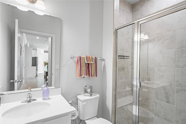 bathroom with vanity, an enclosed shower, and toilet