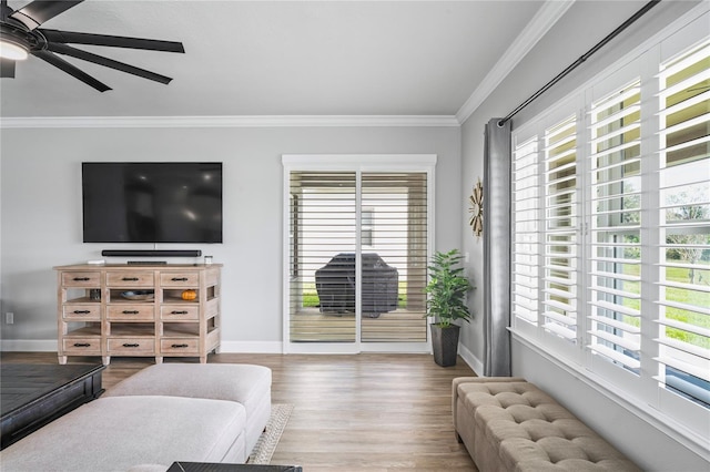 living room featuring ceiling fan, plenty of natural light, ornamental molding, and hardwood / wood-style flooring