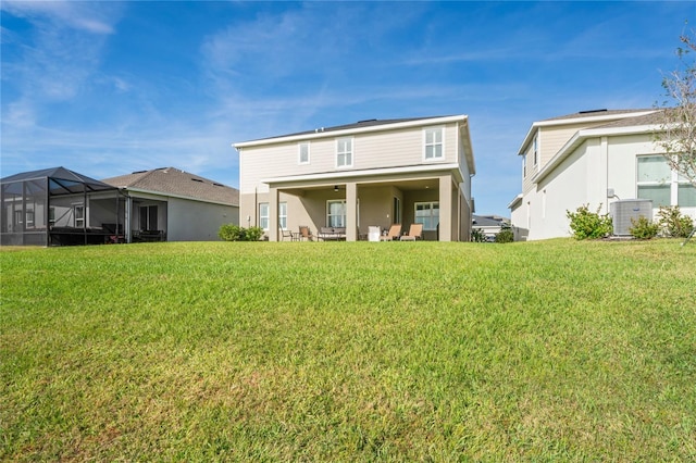 rear view of property featuring glass enclosure, central AC unit, and a lawn