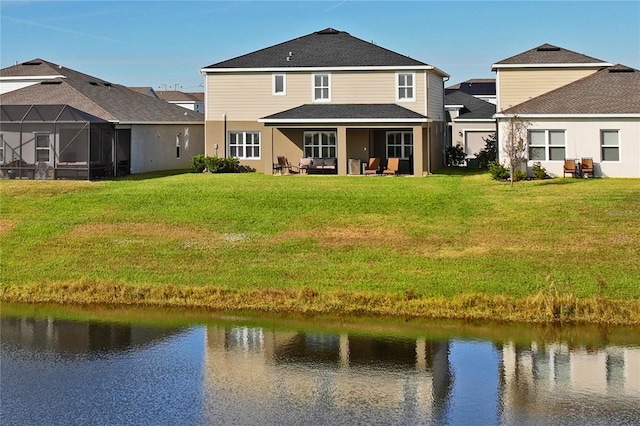 back of house with a lawn, glass enclosure, and a water view