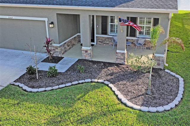 doorway to property with a yard, a porch, and a garage