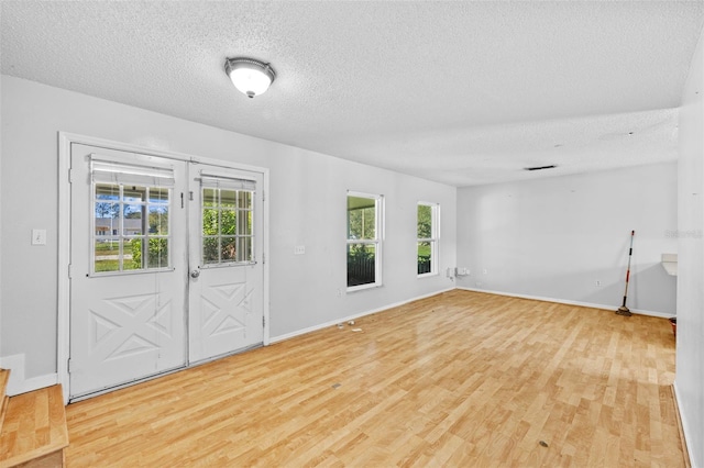 empty room featuring a textured ceiling and light wood-type flooring