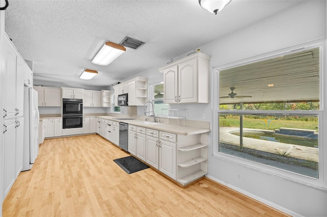 kitchen with dishwasher, a wealth of natural light, light hardwood / wood-style flooring, and white cabinets