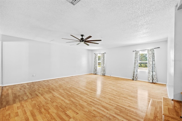 unfurnished room featuring a textured ceiling, light hardwood / wood-style floors, and ceiling fan