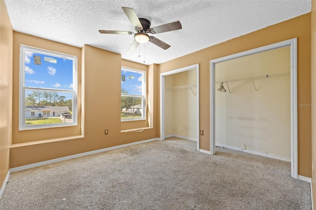 unfurnished bedroom featuring a textured ceiling, light colored carpet, and ceiling fan