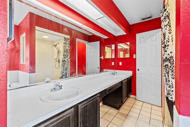 bathroom with a shower with shower curtain, a textured ceiling, vanity, and tile patterned floors