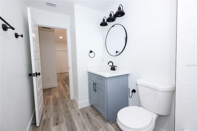 bathroom with hardwood / wood-style flooring, vanity, and toilet