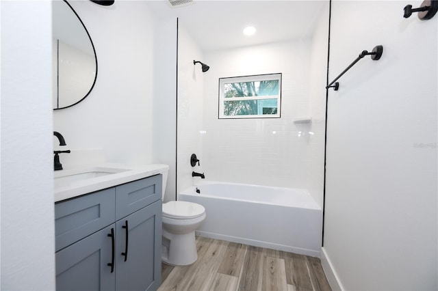 full bathroom featuring tiled shower / bath, wood-type flooring, toilet, and vanity