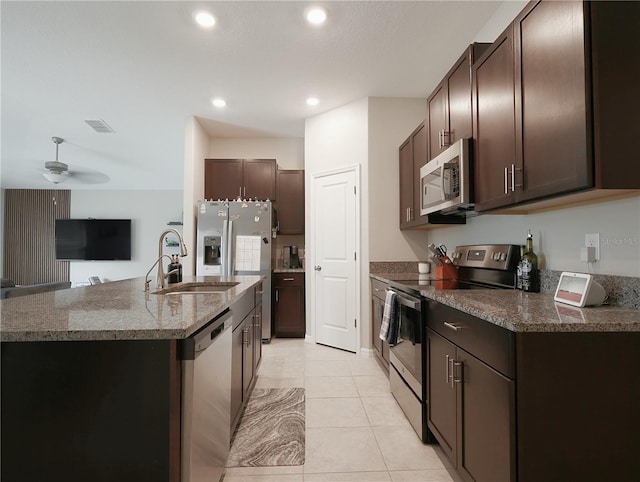 kitchen featuring dark brown cabinetry, stainless steel appliances, ceiling fan, sink, and light tile patterned flooring