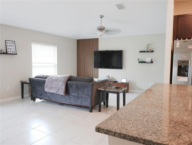 living room with ceiling fan and light tile patterned flooring