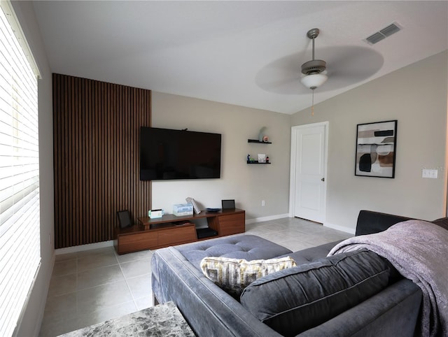 tiled living room with ceiling fan and vaulted ceiling