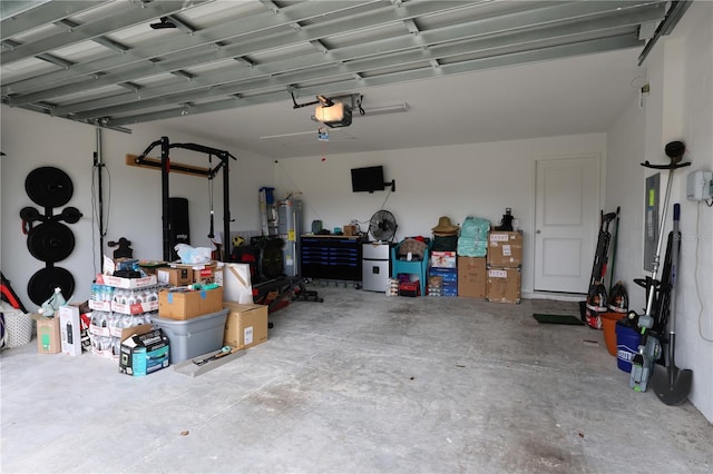 garage with electric panel, electric water heater, and a garage door opener