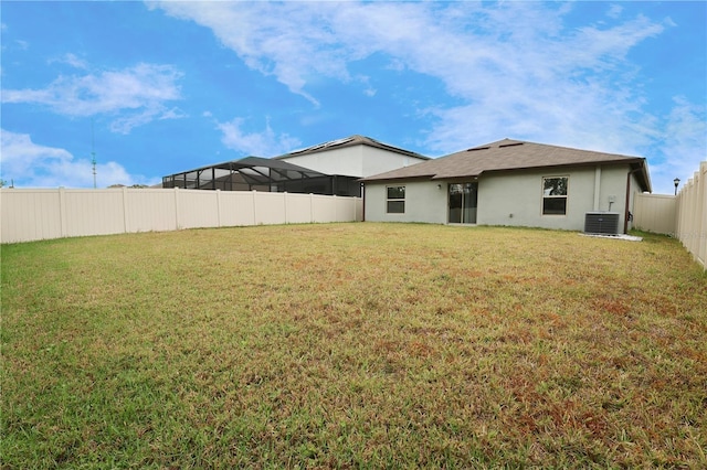 rear view of house with a yard and central AC