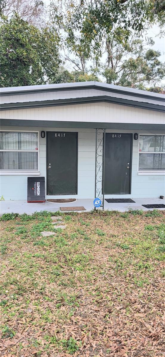 property entrance featuring covered porch and a yard