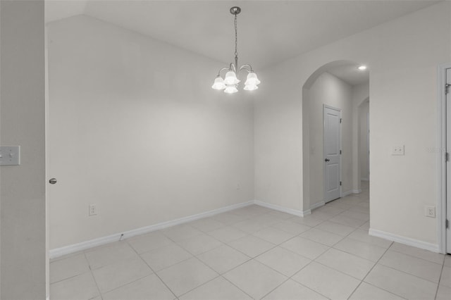 tiled spare room with a notable chandelier