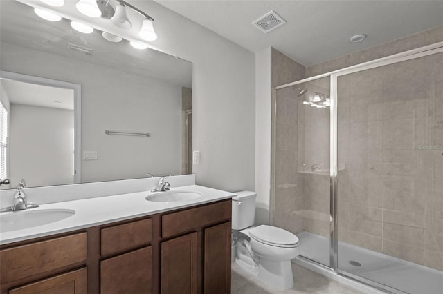 bathroom with vanity, toilet, and a shower with door