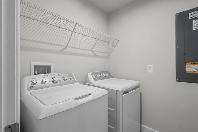 clothes washing area with washing machine and dryer and electric panel