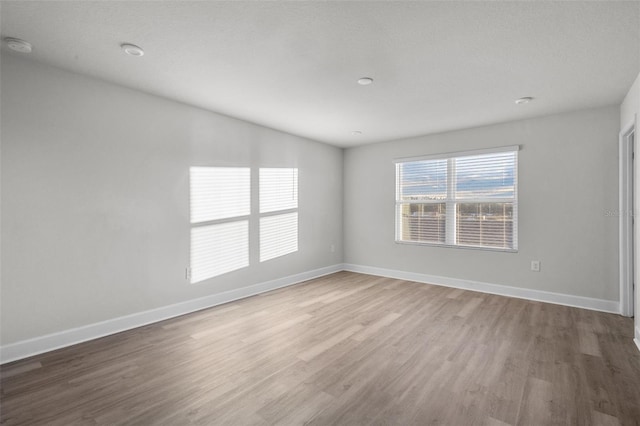 empty room with hardwood / wood-style floors and a textured ceiling